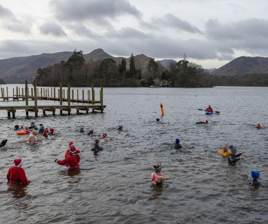 Swimmers in Derwentwater with the mountains behind