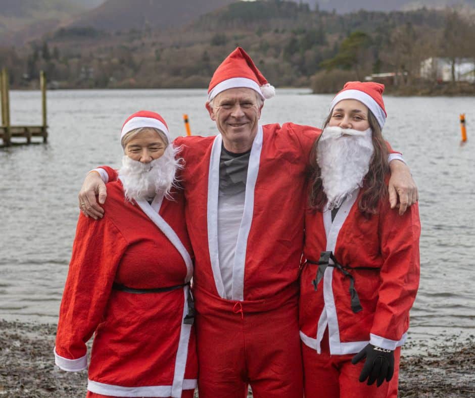 A trio of Santa's on the lakeshore of Derwentwater before entering for a dip