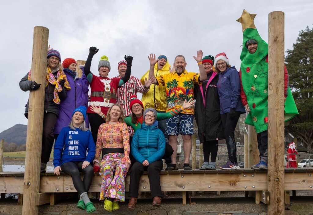Group of people in fancy dress on the jetty in Keswick before swimming in Derwentwater for charity on New Year's Day