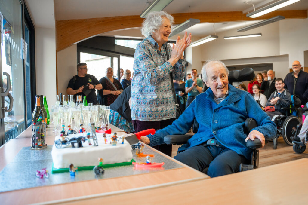 John Fryer-Spedding, founder of Laek District Calvert Trust, sits in his wheelchair to cut the birthday cake