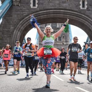 Runner with arms in the air running the London Marathon