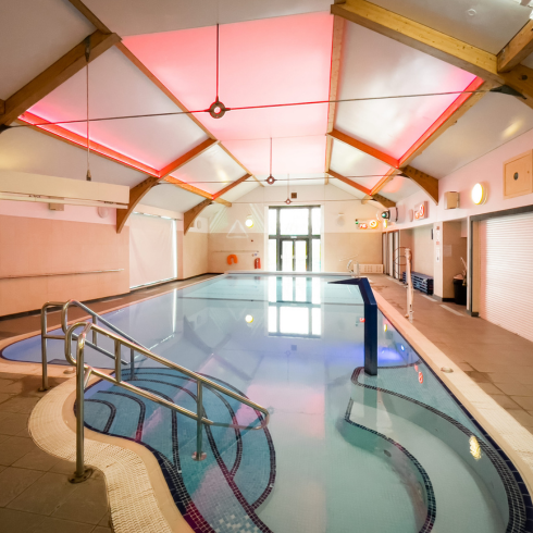 Swimming pool with sensory lights on bathing the pool in pink light