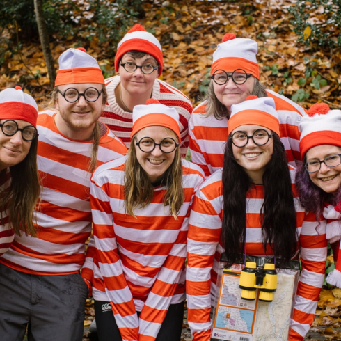 Group of adults wearing Where's Wally tops and hats