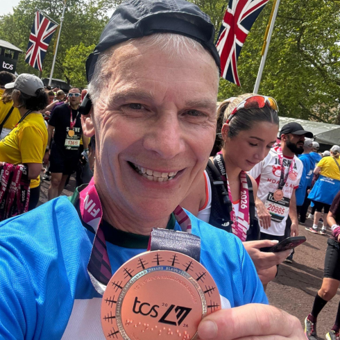 Man with medal after running the London Marathon in 2026