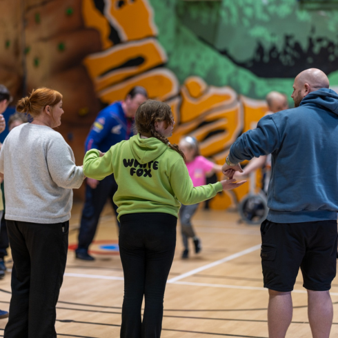 Group doing a standing challenge in a sports hall