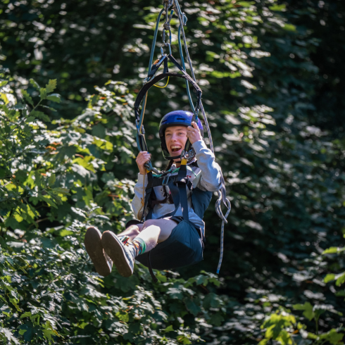 Boy smiling as he flies down a zip wire