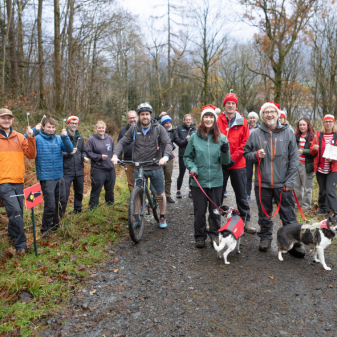 Group of people standing together on a gravel path in the woods