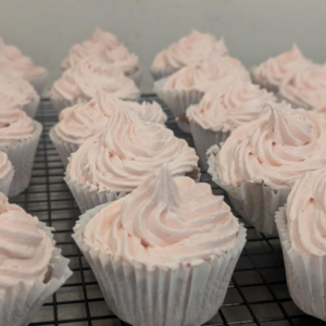 Close up of a tray of cupcakes with pink icing piped on top