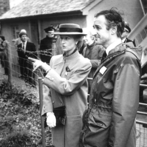 black and white photograph of two people standing with one pointing off camera