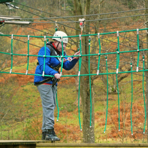 Young man negotiating a high ropes course