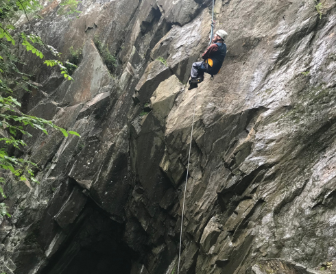 Man abseiling down a rock wall