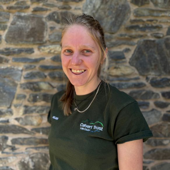 Headshot of staff member Ellen standing in front of a stone wall