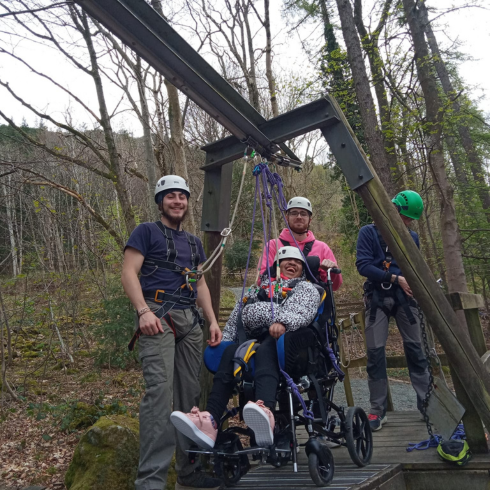 Group on the wheelchair challenge course - one in a chair and three others beside supporting