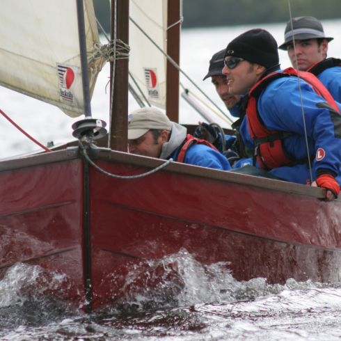 People sitting in a sailing boat as it moves through the water