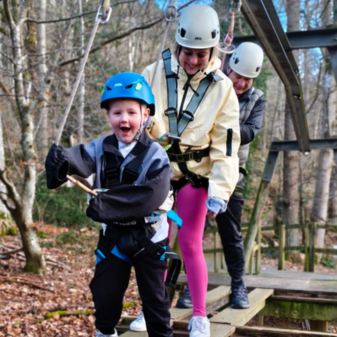 Young boy and his parents walking along the wheelchair challenge course